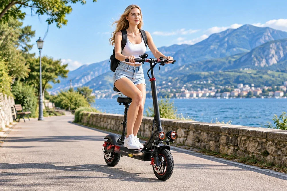 Woman riding Freeboy J01 electric scooter along scenic lakeside mountain promenade