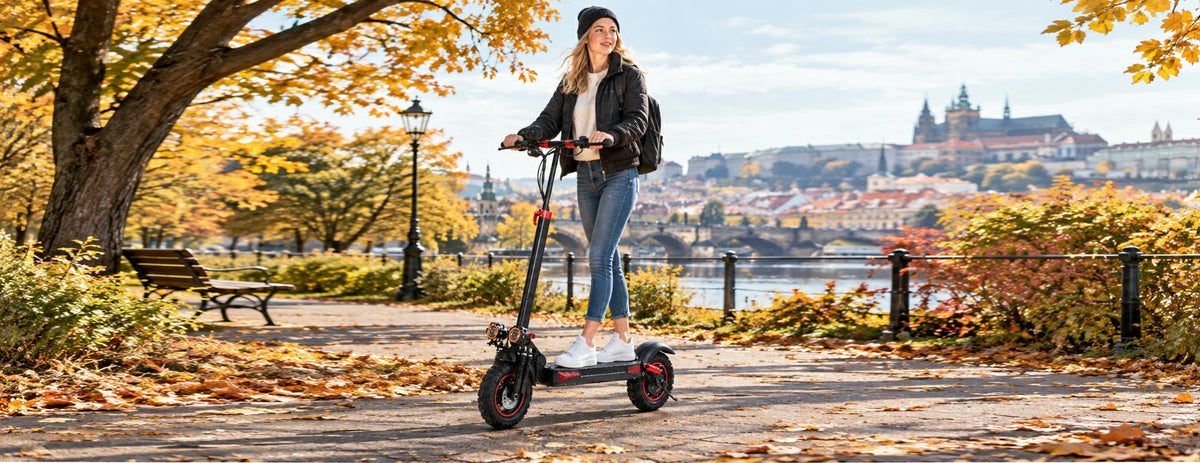 Woman riding Freeboy J11 Max electric scooter on autumn riverside path in Prague.