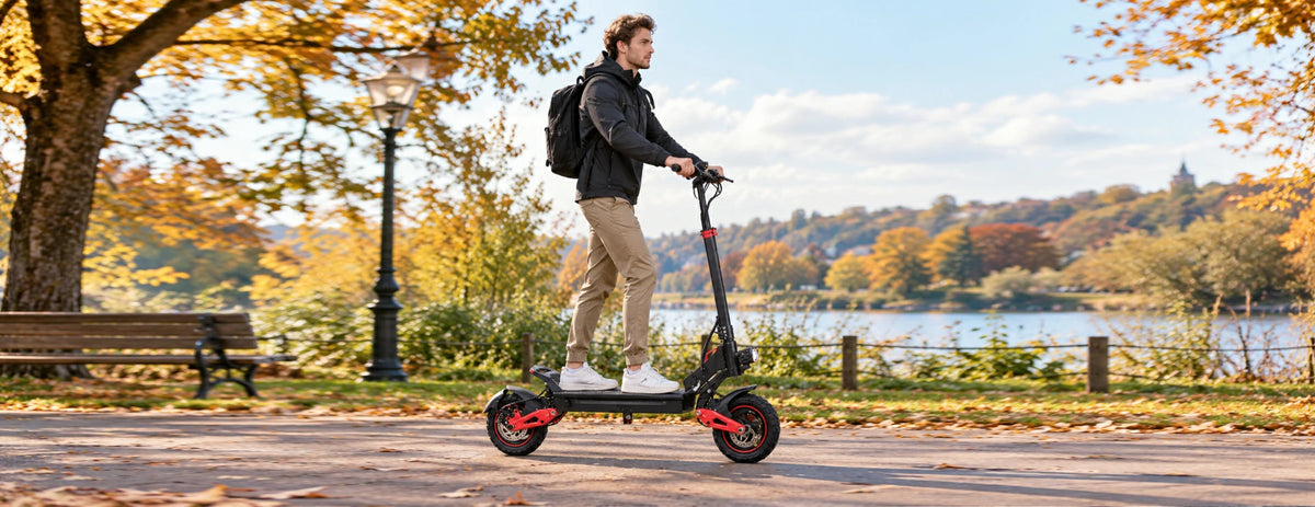 Man riding Freeboy J15 Max electric scooter on autumn lakeside park path.